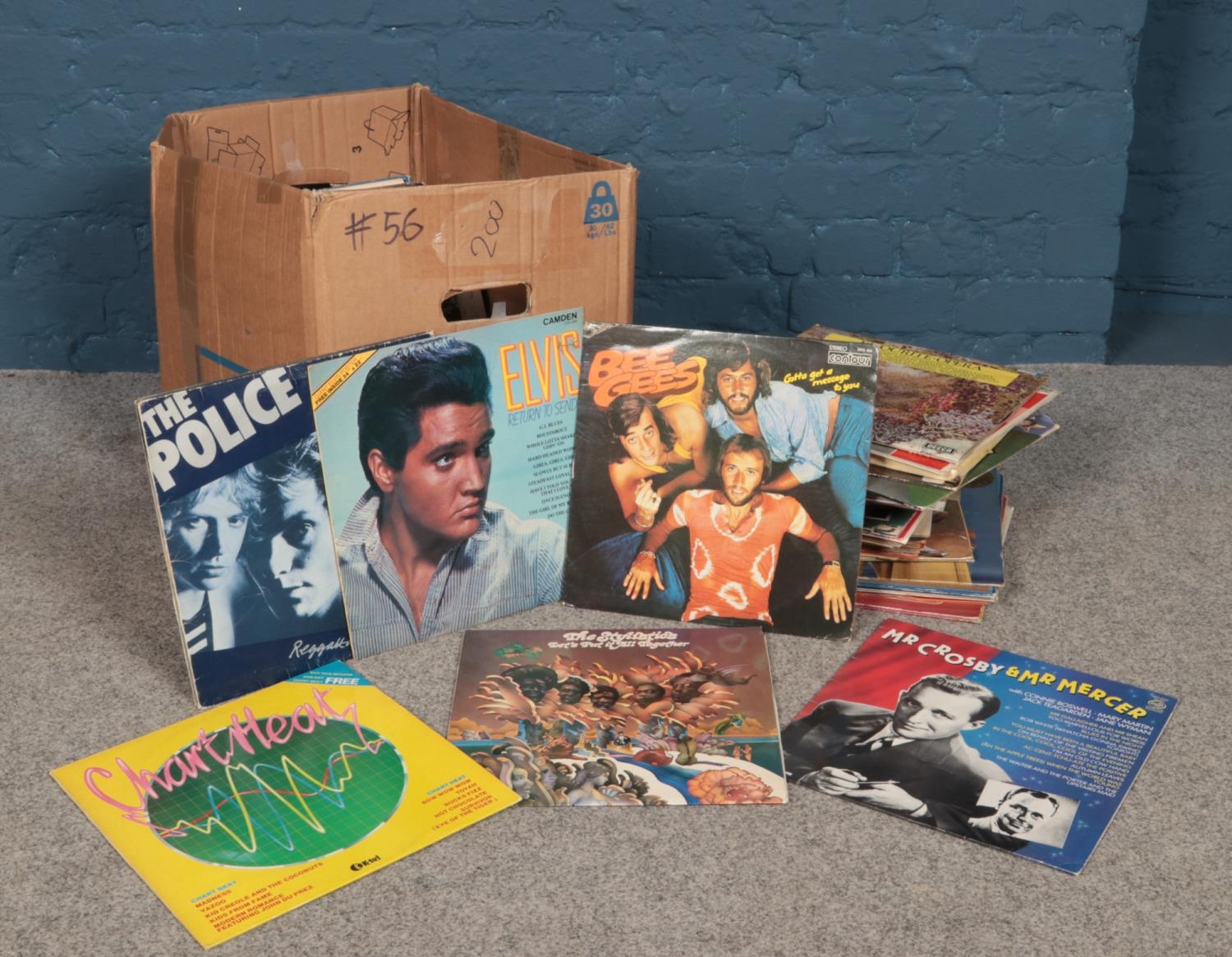A box of assorted 12" vinyl records. Artists to include Paul McCartney, Odyssey, Simon &
