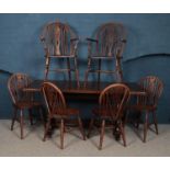An oak refectory dining table along with six wheelback chairs, including two carvers.