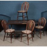 An oak refectory table along with four wheel back dining chairs. (74cm x 137cm)