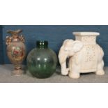 A green glass car boy, ceramic plant stand in the form of an elephant and a ceramic vase.
