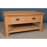 A modern light oak coffee table, with lower shelf and single sliding drawer. Height: 47cm, Width: