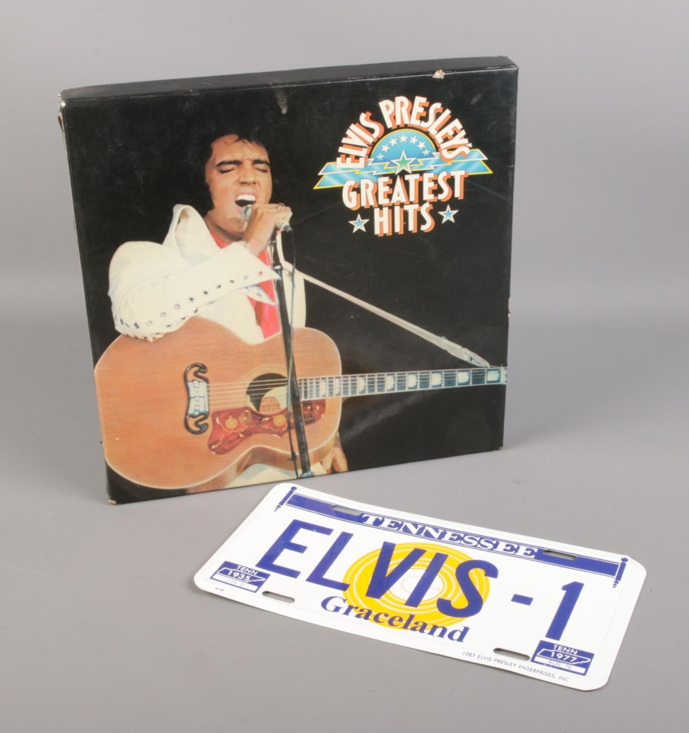 An Elvis Presley greatest hits LP box set along with an enamelled Elvis licence plate.