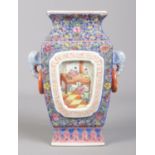 A Chinese twin handled vase decorated in coloured enamels with panels depicting children at play.