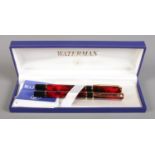 A boxed Waterman matching fountain pen and ball point set, decorated in red marble effect, with