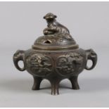 A Chinese bronze lidded censor. The lid surmounted with a temple lion and having elephant mask