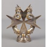 A silver plated Cutajar Works car mascot formed as a Maltese cross surmounted with two dolphins.