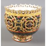 A Zsolnay Pecs reticulated pedestal bowl. Stamped to base 1026. Chips and cracks around rim.