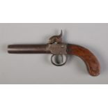 A 19th century percussion cap pistol with screw off barrel and walnut grip.