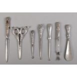 A collection of silver and silver handled utensils; to include button hooks, letter opener and grape