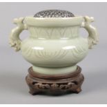 A Chinese celadon censor, with silver meshed inset, raised on carved hardwood stand. Total height