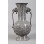 An antique Chinese pewter twin handle vase, decorated with Dog of Fo. 20.5cm. Splits to foot.
