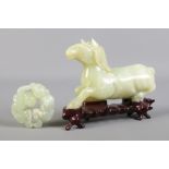 Two pieces of Chinese carved jade. Includes model of a horse on hardwood stand and a bi disc type