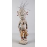 A Papua New Guinea Tribal fertility carving. With shell eyes and grass skirt. H: 52cm