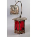 A hanging beaten copper wall light with red Perspex screening.