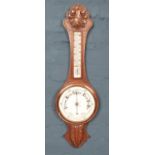 A carved oak banjo aneroid barometer, with foliate detailing to top and bottom. 81cm high.