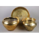 An Eastern brass bowl along with another similar bowl and large charger with Willow pattern