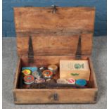 A wooden ammunition box with contents. To include tins of pellets, cartridge belt and gun care kit.