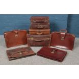 A quantity of leather briefcases, satchels and expanding folders. Clasps damaged on some examples.