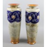 A large pair of Royal Doulton stoneware vases. With moulded bead decoration. (37cm) Crack and
