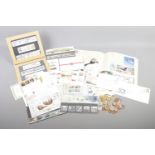 A collection of assorted first day covers, commemorative stamps and coins, including British and