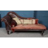 A Victorian chaise lounge with carved mahogany frame.