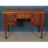 A mahogany desk. With central door flanked by two cupboards. (75cm x 107cm) Top loose at the front