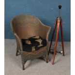 A Lloyd Loom style chair along with a mall tripod standard lamp.