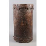 A tooled leather stick stand, with exterior depicting side profiles of busts, possibly Kings and