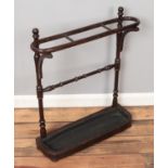 A stained three section stick stand, with turned supports and removable drip tray. Height: 73cm,