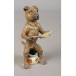 In the style of Franz Bergmann (1861-1936), a cold painted bronze of a dog seated on a potty reading