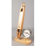 A decorative clock/thermometer formed from an antique cotton shuttle and pressure gauge.