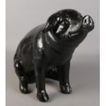 A carbon fibre figure of a seated pig. Height approximately 43cm.