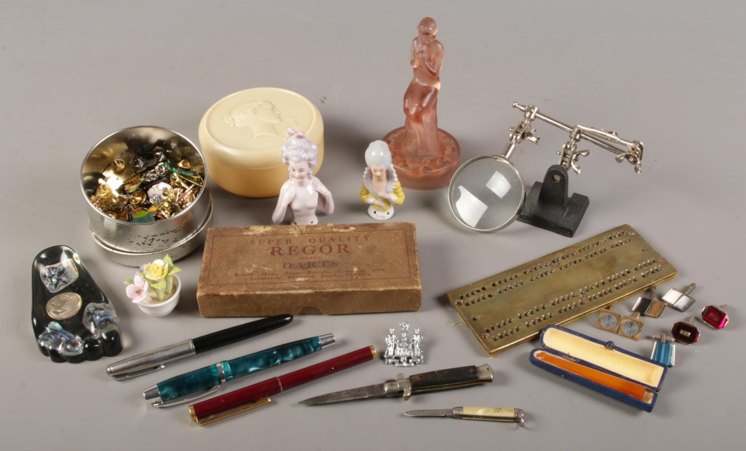 A box of collectables. Includes pen knives, china half dolls, cufflinks etc.