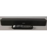 A Bose 5 TV soundbar with remote.