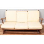 A carved Ercol sofa along with matching armchair. Both with cream upholstery. Comes with spare