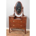 An oak dressing table with oval mirror.
