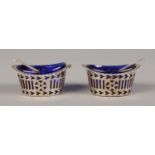 A pair of pierced silver salts, with blue glass liners, together with silver spoons. Salt pots