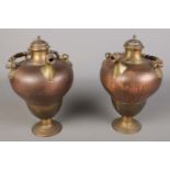 A pair of copper and brass baluster shape water vessels.
