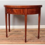 A mahogany demi lune fold over table with lockable drawer and key.