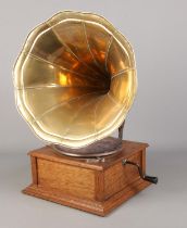 A portable wind up gramophone with oak base and brass funnel. In working order.