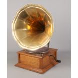 A portable wind up gramophone with oak base and brass funnel. In working order.