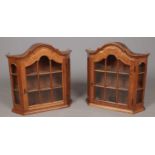 A pair of oak wall cabinets with glass panel doors and sides.