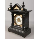 A black and gilt mantel clock with Roman numeral markers.