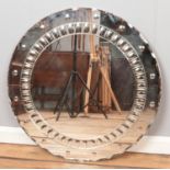 An Art Deco style circular board backed mirror, with angled edging and patterned inner band.