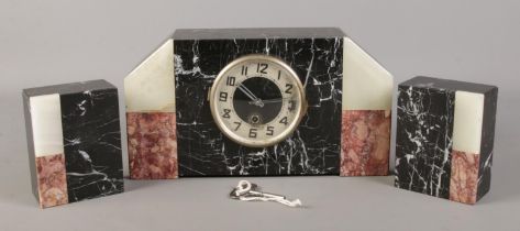 An Art Deco marble and onyx clock garniture. With key. No pendulum.