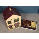 A white two storey dolls house with box of furniture and accessories.