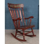 A large hardwood wingback rocking chair, with reeded back and pineapple etched into backrest.
