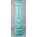 A turquoise Burmantofts jardiniere stand. (81cm) Some chips to the top.