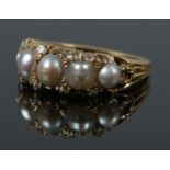A Victorian yellow metal pearl and diamond ring. Size N 1/2. 6.76g.