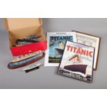 A box of various model ships including Titanic and three naval themed prints.